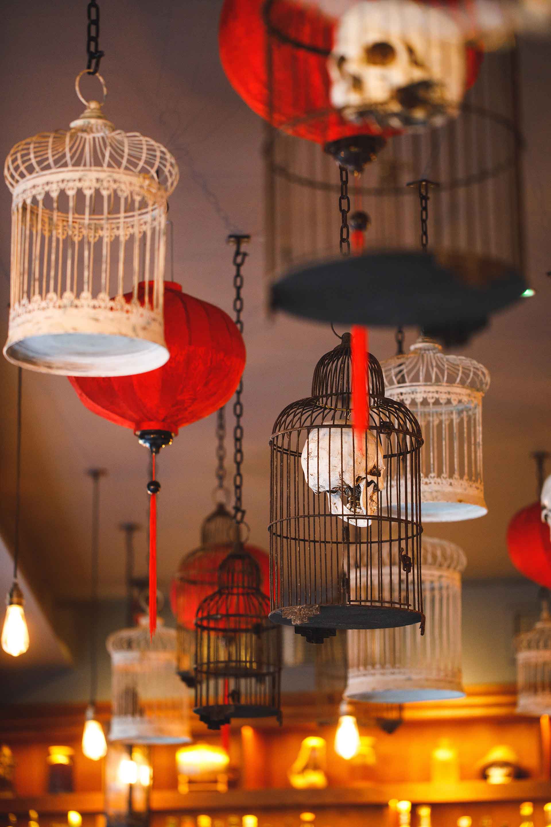 Hanging birdcages and red lanterns above the Siamais dining room