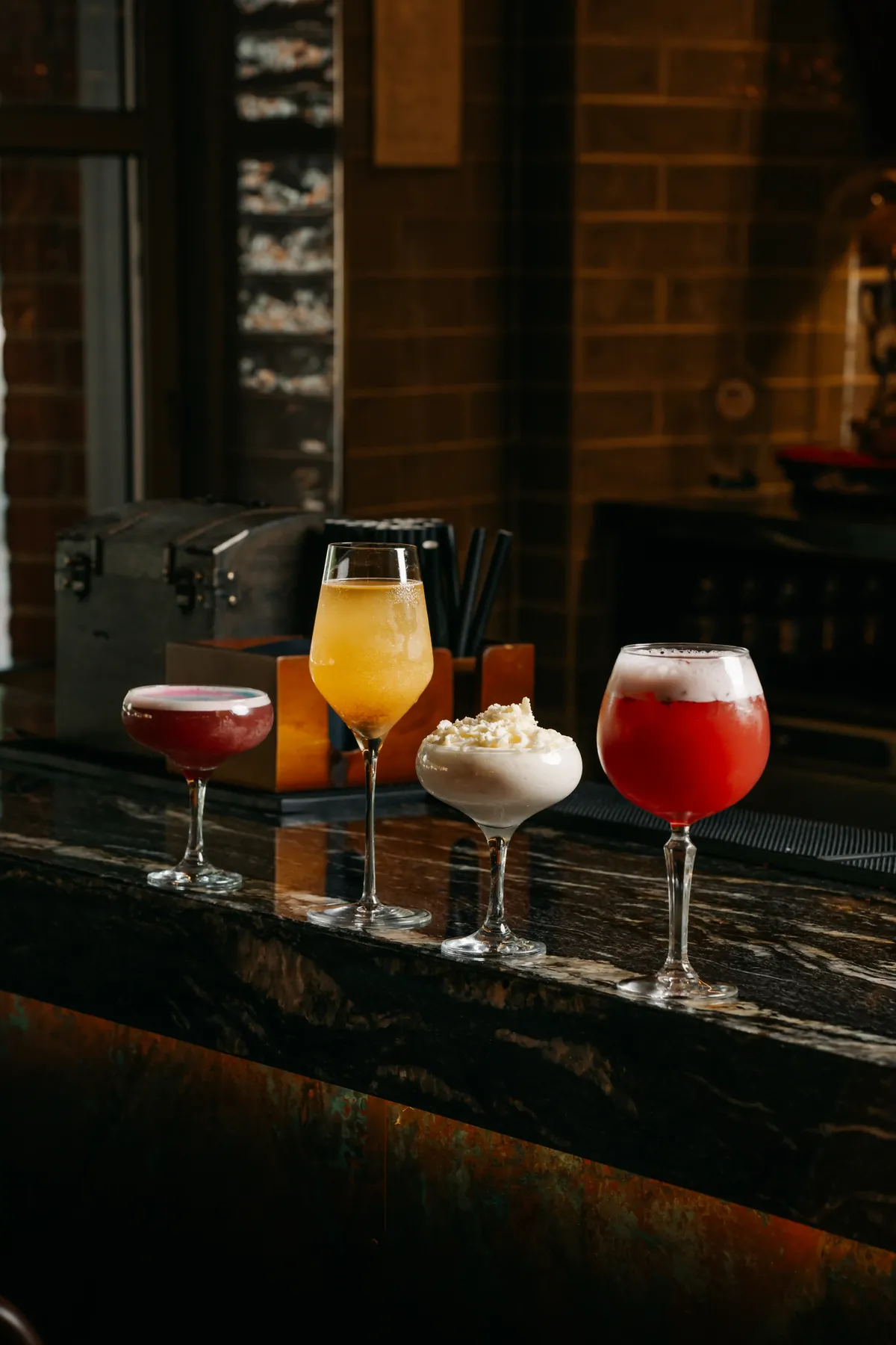 Four Siamais cocktails on the dark marble bar
