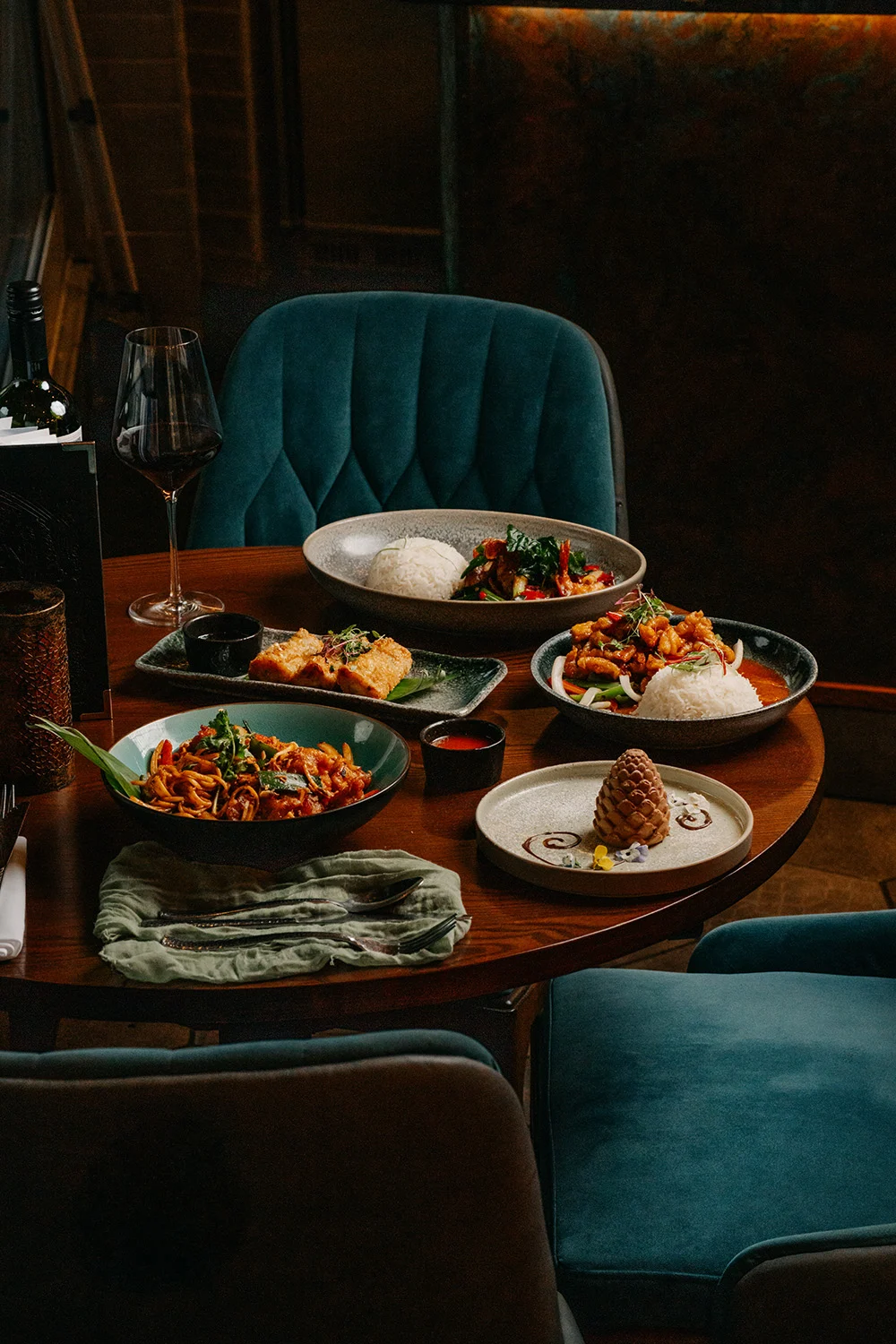 Thai dishes and drinks on a booth table at Siamais during the Christmas season